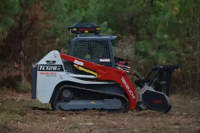 Forestry mulcher clearing brush on a wooded lot